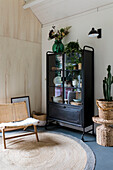 Black display cabinet with plants and rattan decoration