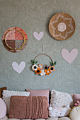 Wall decoration with clock, woven plate and felt flower wreath