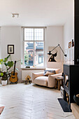 Bright living room with white floorboards, guitar and fireplace
