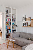 Living room corner with integrated bookshelf and beige sofa