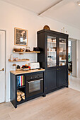 Black display cabinet and built-in oven in a modern kitchen