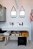 Double washbasin with mirrors and storage baskets in the bathroom