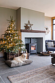 Weihnachtlich dekoriertes Wohnzimmer mit Tannenbaum und Kaminfeuer