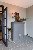 Klassischer Eingangsbereich mit grauem Schrank und dekorativen Gegenständen