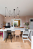 Bright dining area with modern pendant lights and different chairs