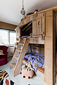 Wooden loft bed with ladder and disco ball in the children's room