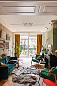 Living room with wooden parquet flooring, velvet sofa and fur rugs, view of terrace