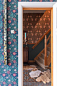 Staircase with patterned wallpaper and tiles and fur rugs