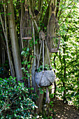 Hanging wicker planters on a tree in the garden