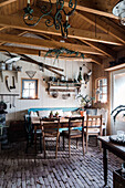 Rustic kitchen interior with wooden furniture, tiled floor and wooden beamed ceiling