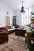Wohnzimmer mit Vintage-Ledermöbeln, antiker Truhe und Weihnachtsbaum