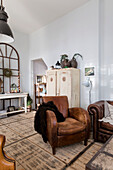 Vintage living room with brown leather armchair and rustic wooden cabinet