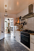 Landhausküche mit weißen Fronten und Metall-Hängelampe