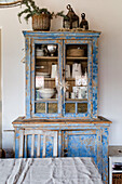 Vintage display cabinet in shabby chic style with crockery and decoration