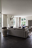 Living room in neutral and grey tones with fireplace and large windows