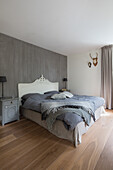 Schlafzimmer mit weißem Barockbett und grauer Wandgestaltung