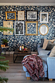 Living room with floral wallpaper, framed pictures and mirror on the wall