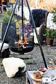 Fire pit in the garden, stools and armchairs with furs