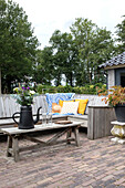 Rustic garden terrace with wooden furniture and flower arrangement