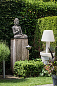 Buddha statue on a wooden plinth in the garden