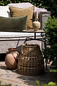 Cozy seating area in the garden with rustic clay pots and wicker decorations