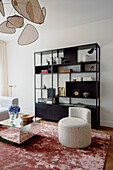 Schwarzes Regal mit Büchern und Dekor im modernen Wohnzimmer