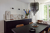 Küchenzeile mit floralem Muster und Essbereich mit Glas-Hängeleuchte und Esstisch mit Stühlen