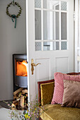 Open door, fireplace, sofa and cushions