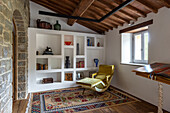 Cozy reading area in rustic living room with built-in shelving and recliner chair