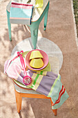 Colorful crockery and tea towel on vintage metal chairs outside