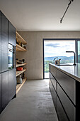 Modern kitchen with black cupboards and mountain views