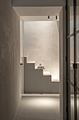 Minimalist staircase with indirect lighting and concrete look