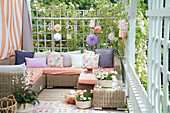 Seating area with colorful cushions and lanterns on a summery terrace