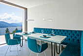 Dining area with turquoise upholstered seating and lake view