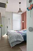 View of bedroom with double bed and pink-coloured curtains