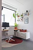 Bright home office with indoor plants and wall shelves