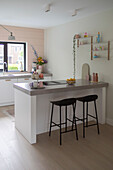 Modern kitchen with cooking island, bar stools and shelves