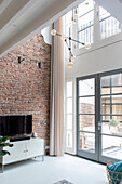 Living room with brick wall, patio door and modern pendant light