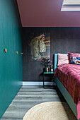 Bedroom with teal-colored built-in wardrobe and rose-colored bedspread