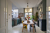 Open-plan kitchen with dining table, colorful chairs and Christmas tree