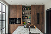 Modern kitchen with dark wooden cabinets and stone island