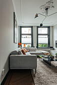 Modern living room with grey corner sofa and sculptural ceiling light