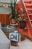 Corner in the living room with houseplants, orange radiator and built-in cupboard under the stairs