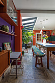 Colorful living dining area with plants and skylights