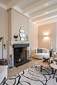 Living room with fireplace, round mirrors and light-colored furniture