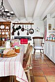 Country kitchen with terracotta tiles and rustic dining table