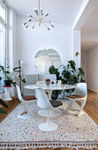 Round marble table with white tulip chairs in modern dining room