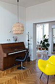 Piano and yellow designer chair in the modern living room