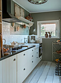 Country-style kitchen with white cabinets, farmhouse sink and rustic decorations