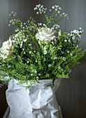 Bouquet of flowers in white and green in paper packaging